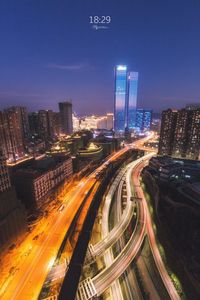 High angle view of illuminated street amidst buildings at night