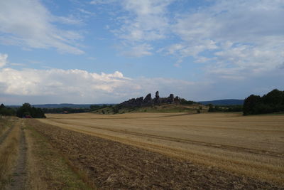 Scenic view of agricultural field and rock formation against sky