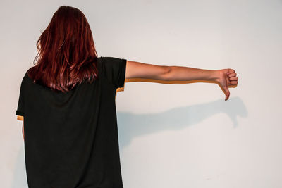 Rear view of woman standing against wall