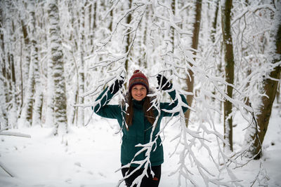 Portrait of young woman standing in snow