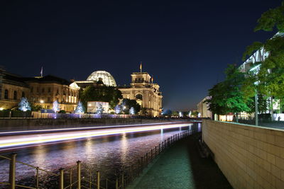 Illuminated city against clear sky at night