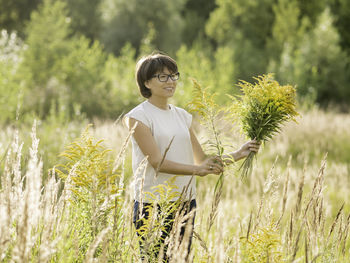 Side view of young woman standing on field