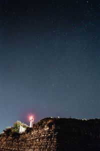 Low angle view of trees against star field at night