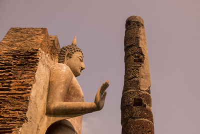 Low angle view of statue against historic building