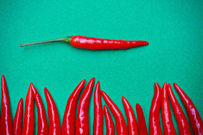 Close-up of red chili peppers over blue background