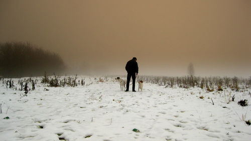 Silhouette of man standing on snow covered landscape