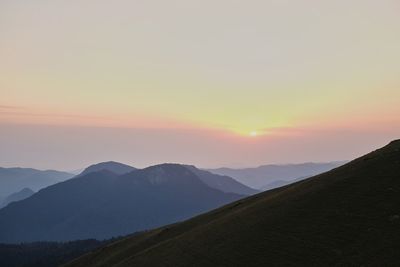 Scenic view of silhouette mountains against sky during sunset