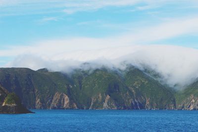 Scenic view of sea and mountains against sky