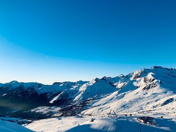 Scenic view of snowcapped mountains against clear blue sky