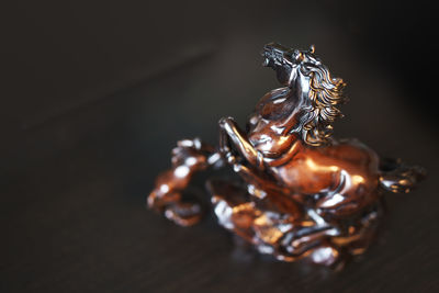 Close-up of sculpture on table against black background