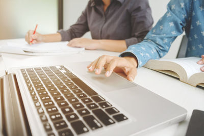 Midsection of man using laptop on table