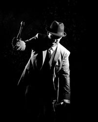 Mafia holding hammers against black background