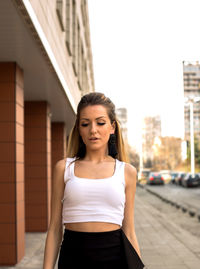 Young woman standing against building