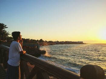 Silhouette of woman standing against clear sky at sunset