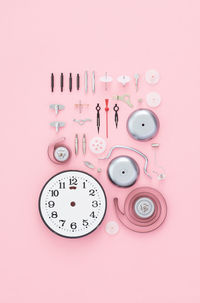 Close-up of clock over pink background