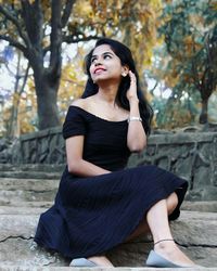 Smiling young woman sitting on steps at sanjay gandhi national park