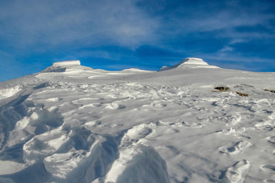 Scenic view of snowcapped mountains against blue sky