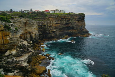 Scenic view of rocks in sea against sky