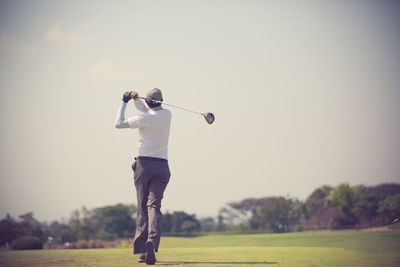 Full length of man playing golf against sky