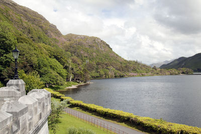 Scenic view of lake by mountains against sky