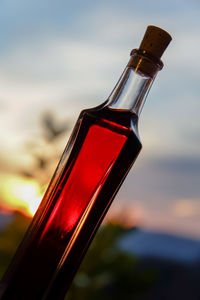 Close-up of beer bottle against sky