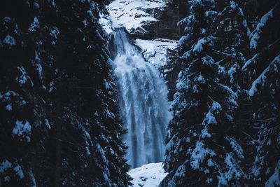 Scenic view of waterfall in forest during winter