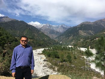 Portrait of confident mature man standing on mountain