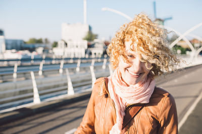 Portrait of smiling young woman against river