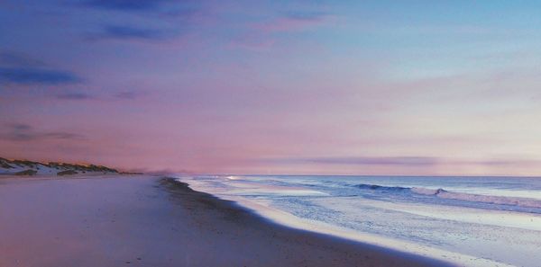 Scenic view of beach against sky during sunset