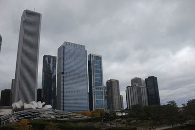 Modern buildings in city against cloudy sky