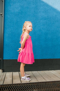 Portrait of woman standing against wall