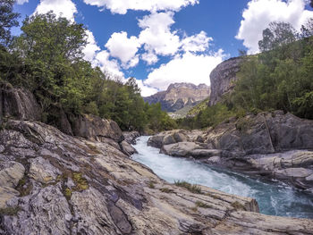 Scenic view of river amidst mountains against sky