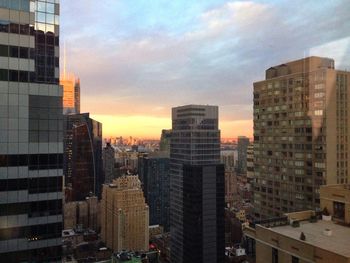 Buildings in city against cloudy sky