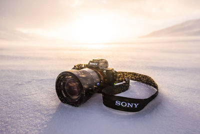 Close-up of camera on table against sky during sunset