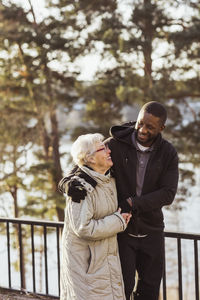 Smiling male nurse walking with senior woman in park