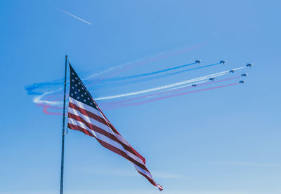 Low angle view of flag against clear blue sky