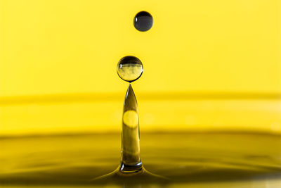 Close-up of yellow drop against gray background