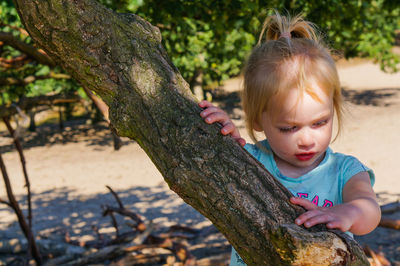 Close-up of cute girl standing by tree