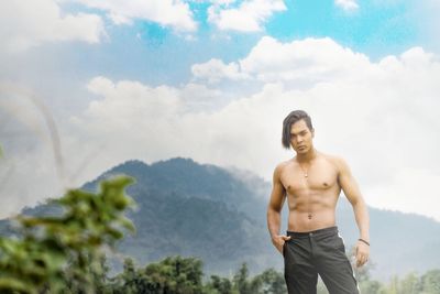 Portrait of young man standing against sky