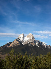 Low angle view of rocky mountains against blue sky