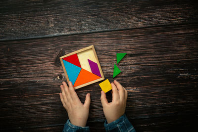 Cropped hands of woman holding gift box on table