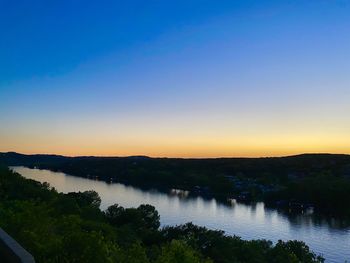 Scenic view of lake against clear sky at sunset