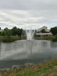 Fountain in park against cloudy sky