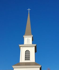 Low angle view of bell tower against blue sky