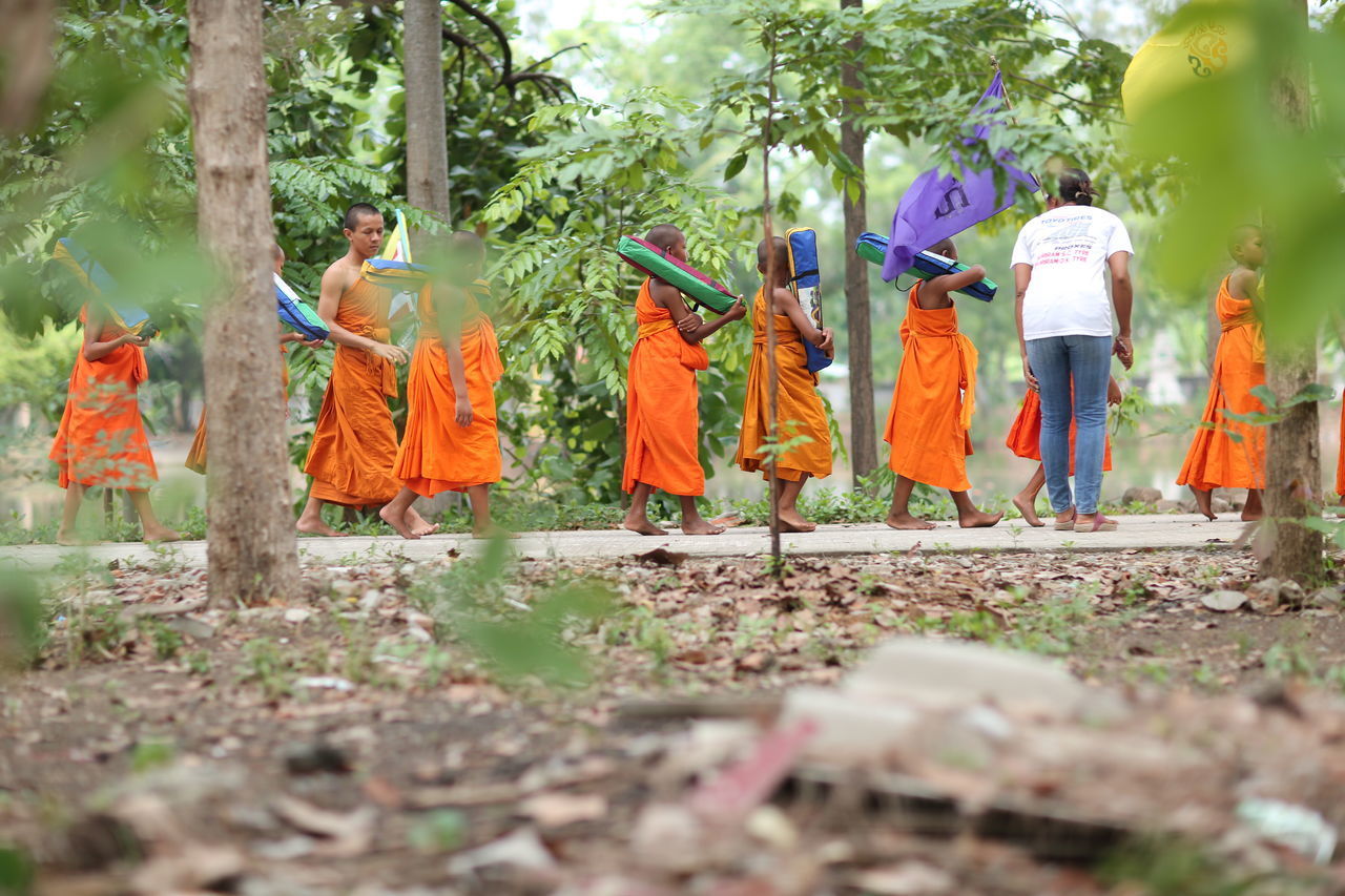 REAR VIEW OF PEOPLE WORKING ON PLANT