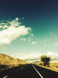 Road by landscape against sky