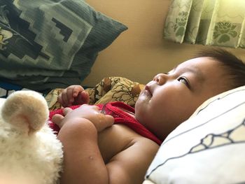 Close-up of baby boy lying on bed