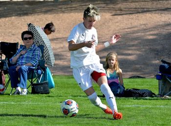 Children playing soccer on field