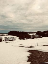 Scenic view of snow covered field against sky