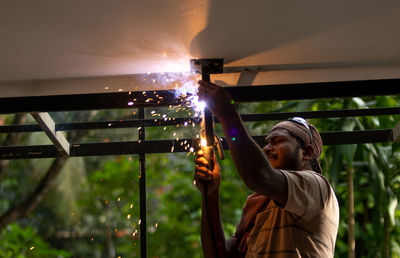 A man doing welding works on roof top